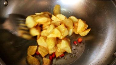 薯块回锅翻炒入辣味。