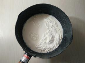 将白砂糖和玉米淀粉倒入不粘锅,倒入配方中一半牛奶，搅拌均匀，以免淀粉沉底。