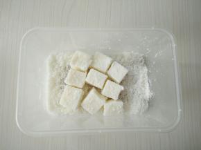容器里倒入适量椰蓉，将牛奶小方充分裹上椰蓉。