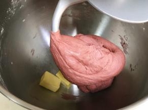 揉至成团后，往搅拌桶内加入黄油。