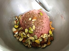 加入切好的开心果、杏仁、核桃和亚麻籽，搅拌2～3分钟，用手整理好面团。