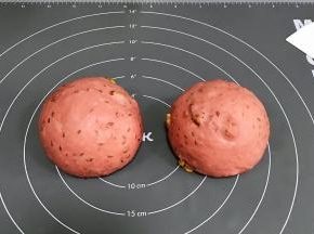 将面团取出排气，均分成两份，接着滚圆，盖好保鲜膜松弛15分钟。