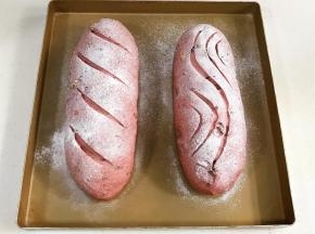 发至两倍大时取出面包，在表面筛一层薄薄的高筋面粉，用锋利的刀片在面包表面刮出纹理。