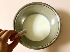 先倒一小部分纯牛奶到盆中，倒入一袋酸奶发酵菌，充分搅拌均匀。
