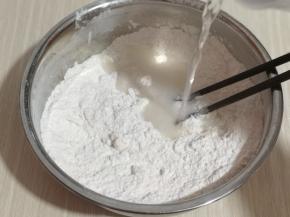 一边加入纯净水，一边用筷子搅拌成絮状， 揉成光滑的面团。