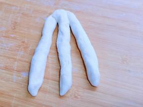 取3条面条，用掌心搓圆拉长，将三条面条顶部捏紧。