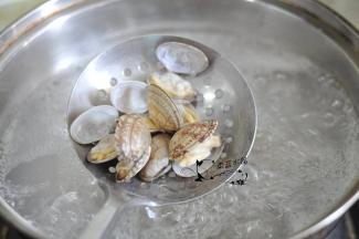 将蛤蜊仔细清洗干净。锅里烧开水，放入蛤蜊煮至张嘴捞出，再清洗一次。