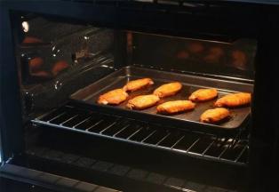 烘烤完成，

戴隔热手套把烤盘取出，

趁热用专门的食品夹把鸡翅夹出摆盘。