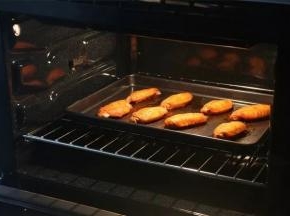 烘烤完成，

戴隔热手套把烤盘取出，

趁热用专门的食品夹把鸡翅夹出摆盘。