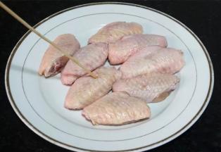 用竹签在鸡翅中的双面都扎些小孔。