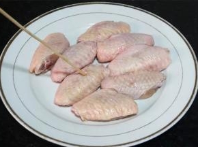 用竹签在鸡翅中的双面都扎些小孔。
