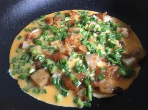 粽子两面煎黄或表皮煎出少许锅巴后均匀倒入鸡蛋液，中大火煎至；