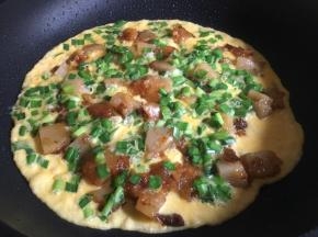 煎至蛋液表面凝固，盖上锅盖小火焖2分钟左右即可出锅装盘；