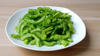 苦瓜对半切开，挖瓤，苦味的瓤尽量都去除干净，苦瓜切薄片。