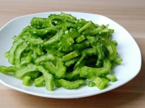 苦瓜对半切开，挖瓤，苦味的瓤尽量都去除干净，苦瓜切薄片。