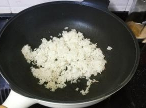 章鱼丸切成小粒备用；锅里热油倒入一碗剩米饭翻炒均匀