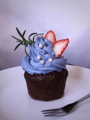 挤在纸杯蛋糕上，用草莓和糖珠装饰。