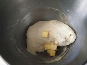 将除黄油和香肠外的所有主面团材料倒入厨师机， 揉成光滑的面团 ，加入黄油继续揉至完全阶段 。