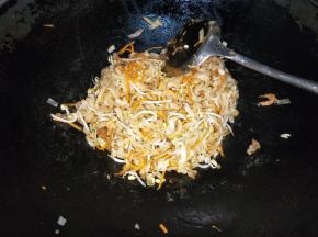放入芽菜和红萝卜，快速翻炒，最后放入鸡精，味精。翻炒均匀。不放水，整个河粉是干炒的。
