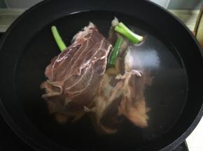 牛腱子泡在清水中，去除血水。放在炒锅中，加入葱姜，冷水煮开，撇去血沫。