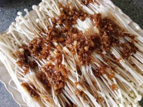 把酱汁均匀倒在金针菇上