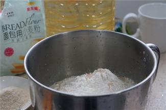 现在我们先来揉面，将液态食材全部先加入，然后再加入称量好的面包粉及酵母。