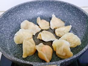 将煮熟的饺子摆放在不粘锅中。