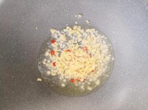 锅中倒入少许油，放入蒜末和小米辣，小火炒出香味。