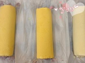 用擀面杖卷住油纸，顺势往上推，卷起来，两边跟拧糖一样拧起来。放入冰箱冷藏半小时后再切块食用。