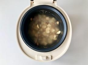 把大米、小米、燕麦米和花生混合洗净，和红薯丁、山药丁一起放入韩国酷晨电饭煲，加入清水。