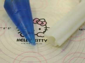 把稍放凉的蓝色白凉粉水装入裱花袋，准备一个心形硅胶夹心模。