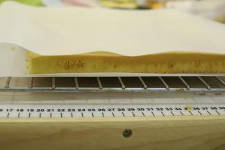 出炉的蛋糕卷轻震一下，放2分钟后倒扣备用。