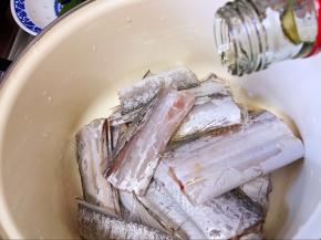 带鱼洗净切段，放入碗中，倒入料酒