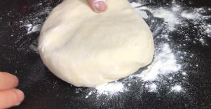案台上撒上干粉，取出面团按成圆饼