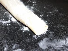 抽出擀面杖，再在面皮上撒一层干粉