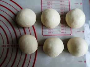 把揉好的面团取出来，分成11等份，揉圆，并盖上保鲜膜，松驰15分钟