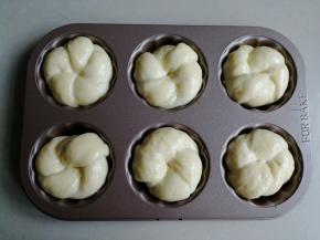 放入6连模里，这样烘烤出来的形状更好看，没有模具的话，直接放在烤盘上烘烤也可以的。放入烤箱内，再放置一碗温热水，使烤箱内部达到一定的湿度，用烤箱的发酵档，发酵至两倍大。没有发酵功能的烤箱，就通过勤换热水来达到合适的温度