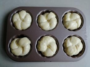 放入6连模里，这样烘烤出来的形状更好看，没有模具的话，直接放在烤盘上烘烤也可以的。放入烤箱内，再放置一碗温热水，使烤箱内部达到一定的湿度，用烤箱的发酵档，发酵至两倍大。没有发酵功能的烤箱，就通过勤换热水来达到合适的温度