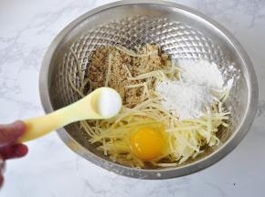 土豆提前去皮用擦板擦成细丝，不必清洗，直接加入鸡蛋，面粉，煮好的藜麦，再加入少许盐。盐不要太多，我大概放了二克左右。