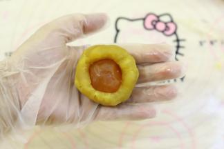 月饼馅平均分成50克一份，蛋黄为10克，包好喷了白酒的蛋黄。