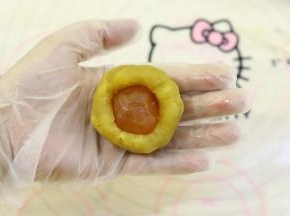 月饼馅平均分成50克一份，蛋黄为10克，包好喷了白酒的蛋黄。