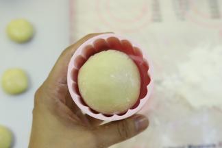 表面滚少许月饼粉，放入月饼膜。