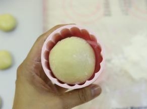表面滚少许月饼粉，放入月饼膜。
