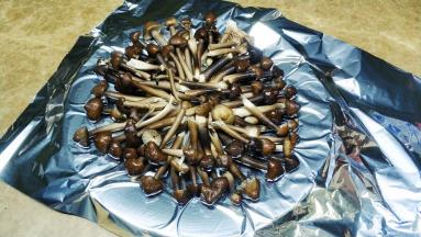 将软化好的黄油抹在锡纸低，洒上蒜盐，码上鸡枞菌