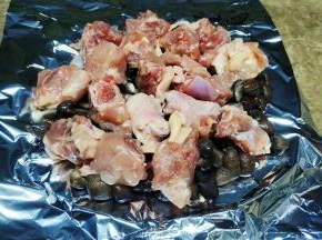 再将腌好的鸡腿块放上鸡枞菌面