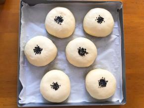 二次发酵完成后，喷点水，撒上黑芝麻