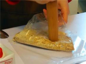 消化饼干放袋中，用面棍横敲、竖敲、再压饼干成碎末（或掰碎放入料理机中）。