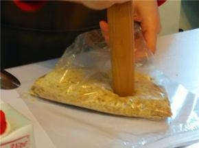 消化饼干放袋中，用面棍横敲、竖敲、再压饼干成碎末（或掰碎放入料理机中）。