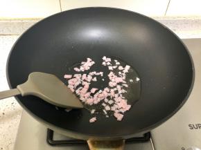 炒锅烧热，放入适量植物油，下切碎的火腿翻炒；