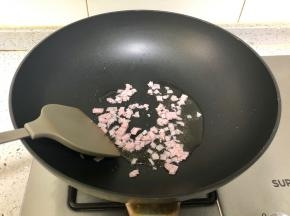 炒锅烧热，放入适量植物油，下切碎的火腿翻炒；